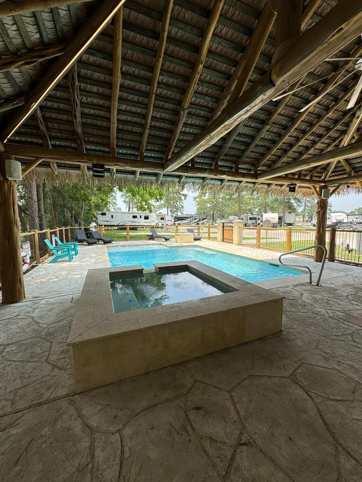 Daytime view of the resort pool and spa under the thatched palapa